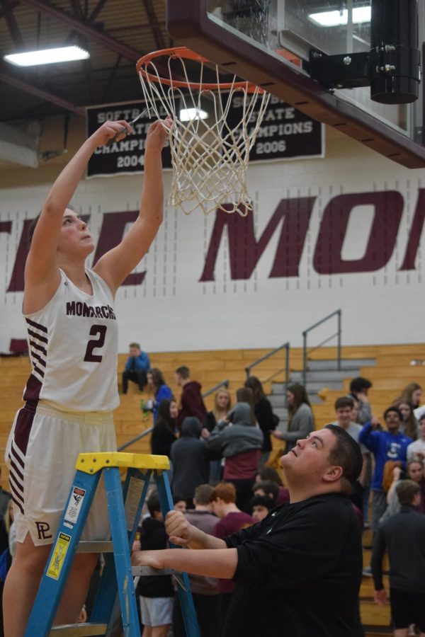 Junior Olivia Boudreau continues the Monarch tradition of cutting the net following their victory at districts.