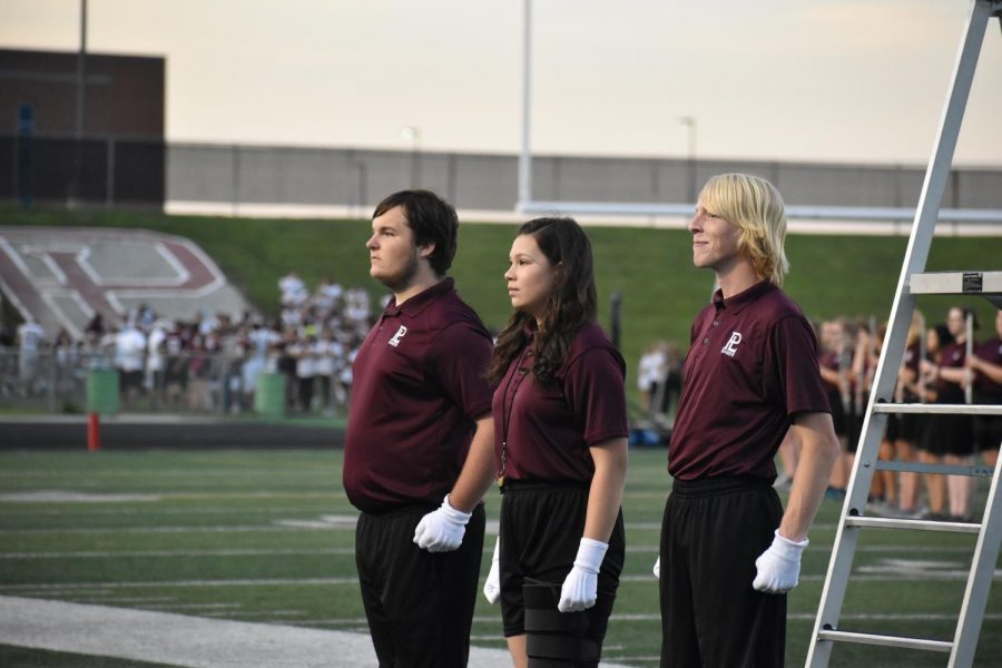 The marching bands three drum majors stand proud before their first full performance. They had a successful halftime, with their entire show on the field.