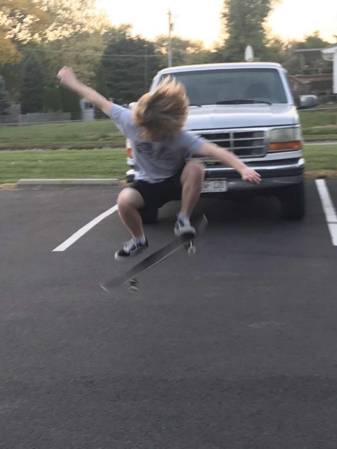 Dayton Conley does an ollie in a parking lot.