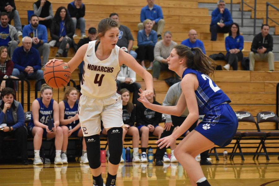 Junior guard Jenna Hoelcher dribbles the ball against Kearney Thursday night. Hoelscher had five points and seven rebounds in the Monarchs win.