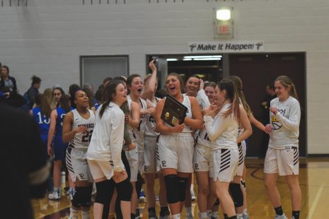 The girls basketball team celebrates their district championship victory.