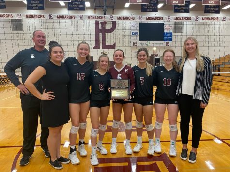 Volleyball seniors, Karli Ahlers, Lily Ziebarth, Sam Riggs, Kenzy Povich, and Allison Sander pose with coaches John Svehla, Justice Stalder, and Priscilla ODowd with the district championship plaque. This was Svehlas last district championship win before resigning.