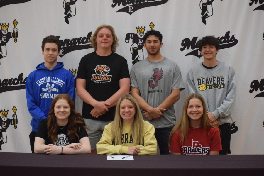 Seniors Henry Belik, Andrew Schmidtz, Nick Chanez, Kade Stover, Allison Sander, Lily Ziebarth, and Audriana Niemeyer smile for the camera after they signed to their colleges. 