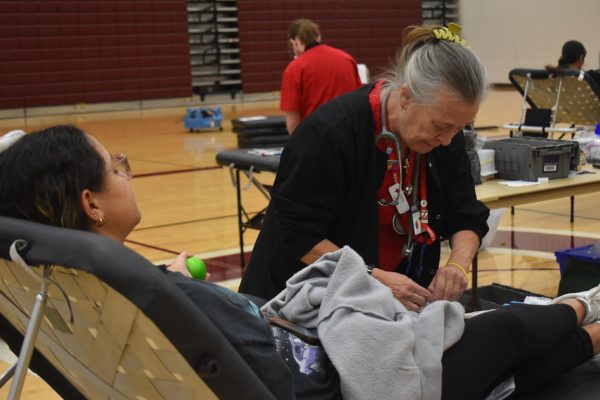 A student is prepped to have her blood drawn by an American Red Cross nurse.