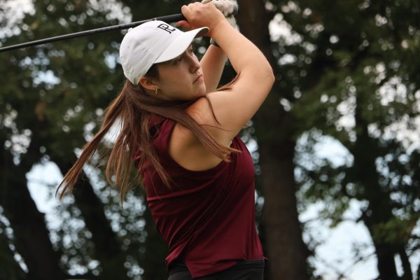 Audra Demory mid swing after striking the golf ball.