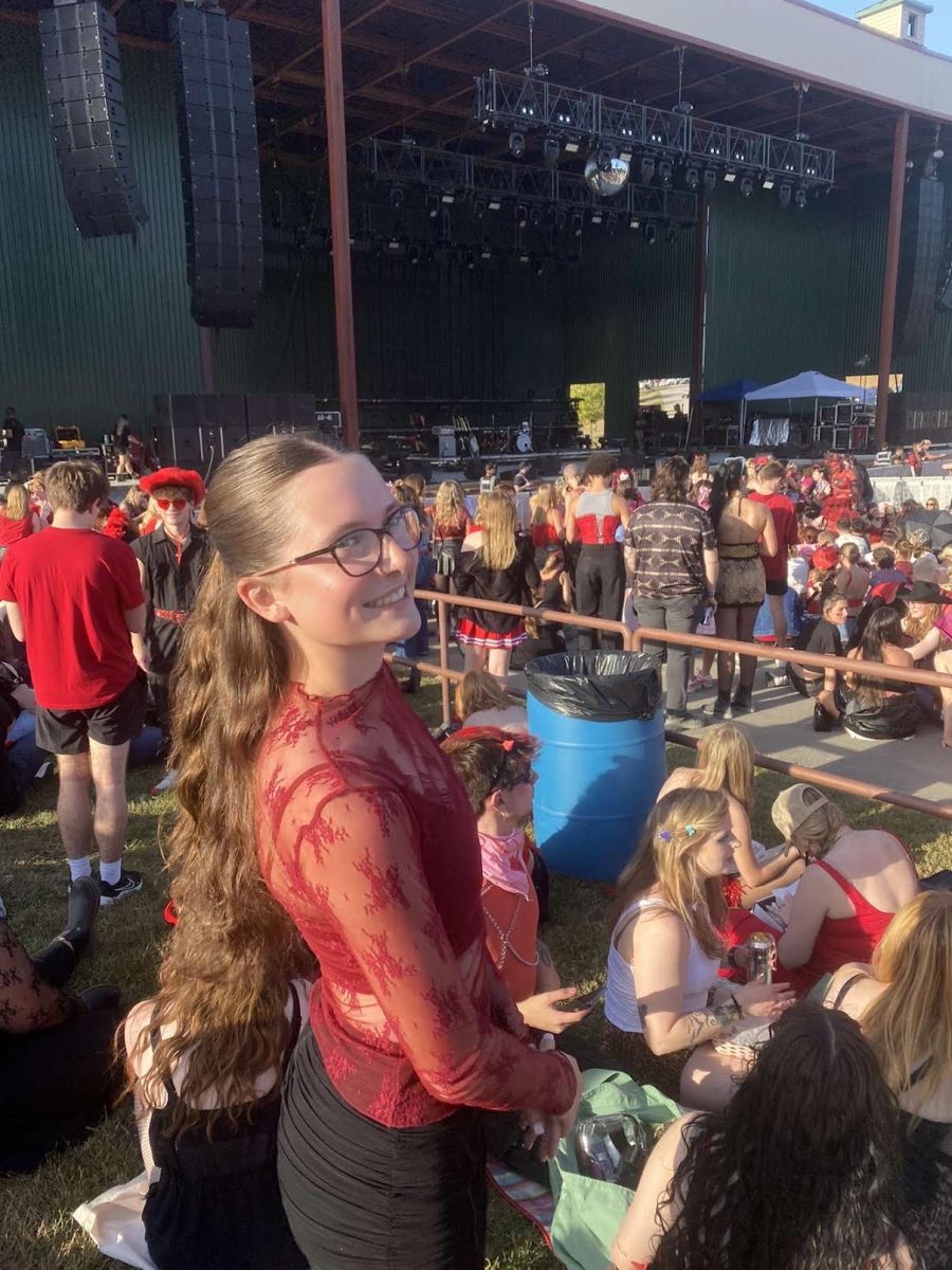 Senior Allison Campbell smiles in front of the stage. “I became a fan of her after [she opened] for Olivia Rodrigo,” Campbell said.