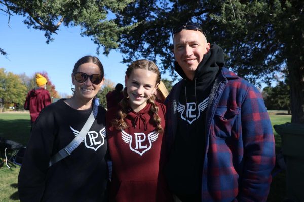 Junior Layla Phillips poses with her proud parents after placing 11th at State Cross Country. 