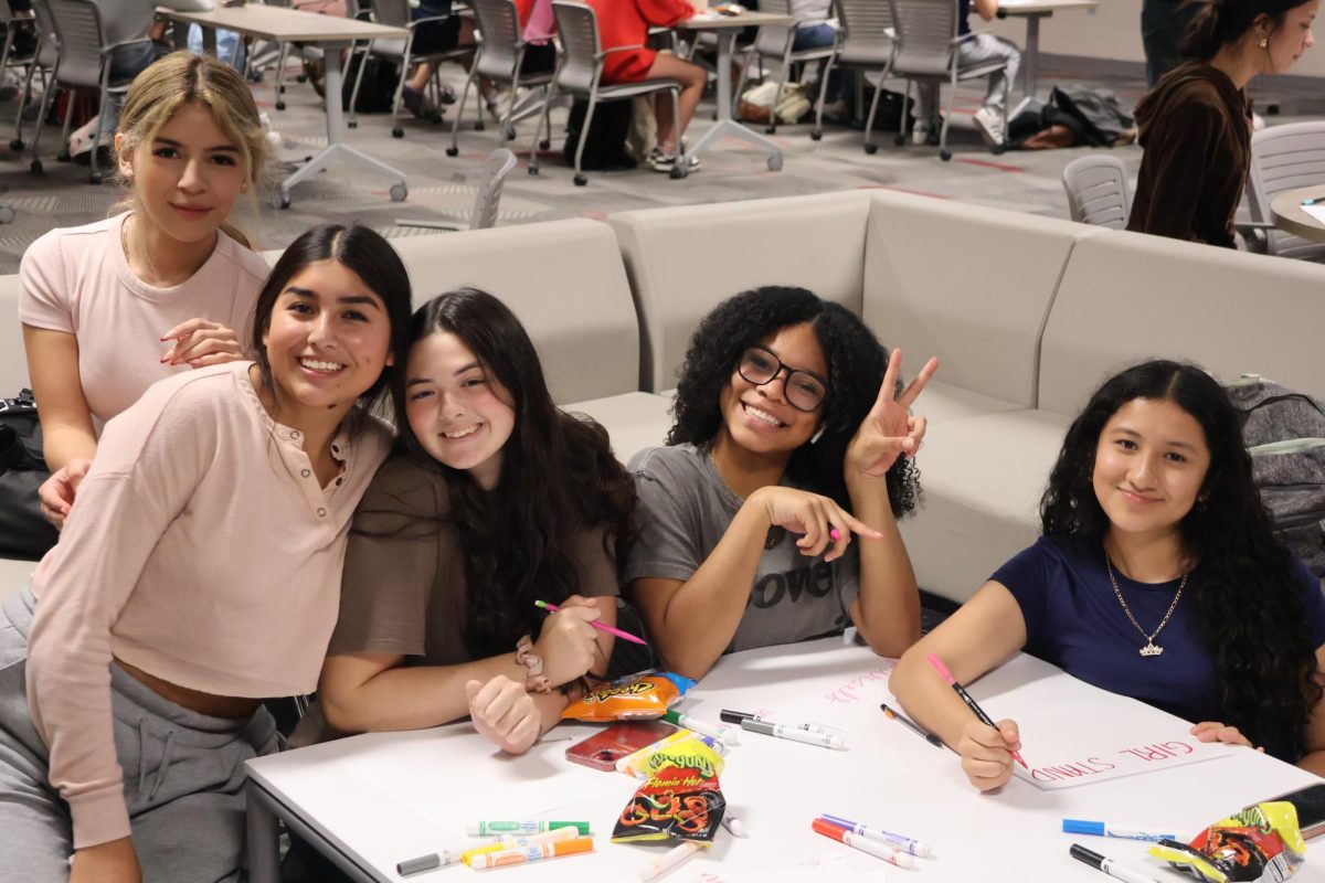 Empower HER members spend quality time together while making posters.