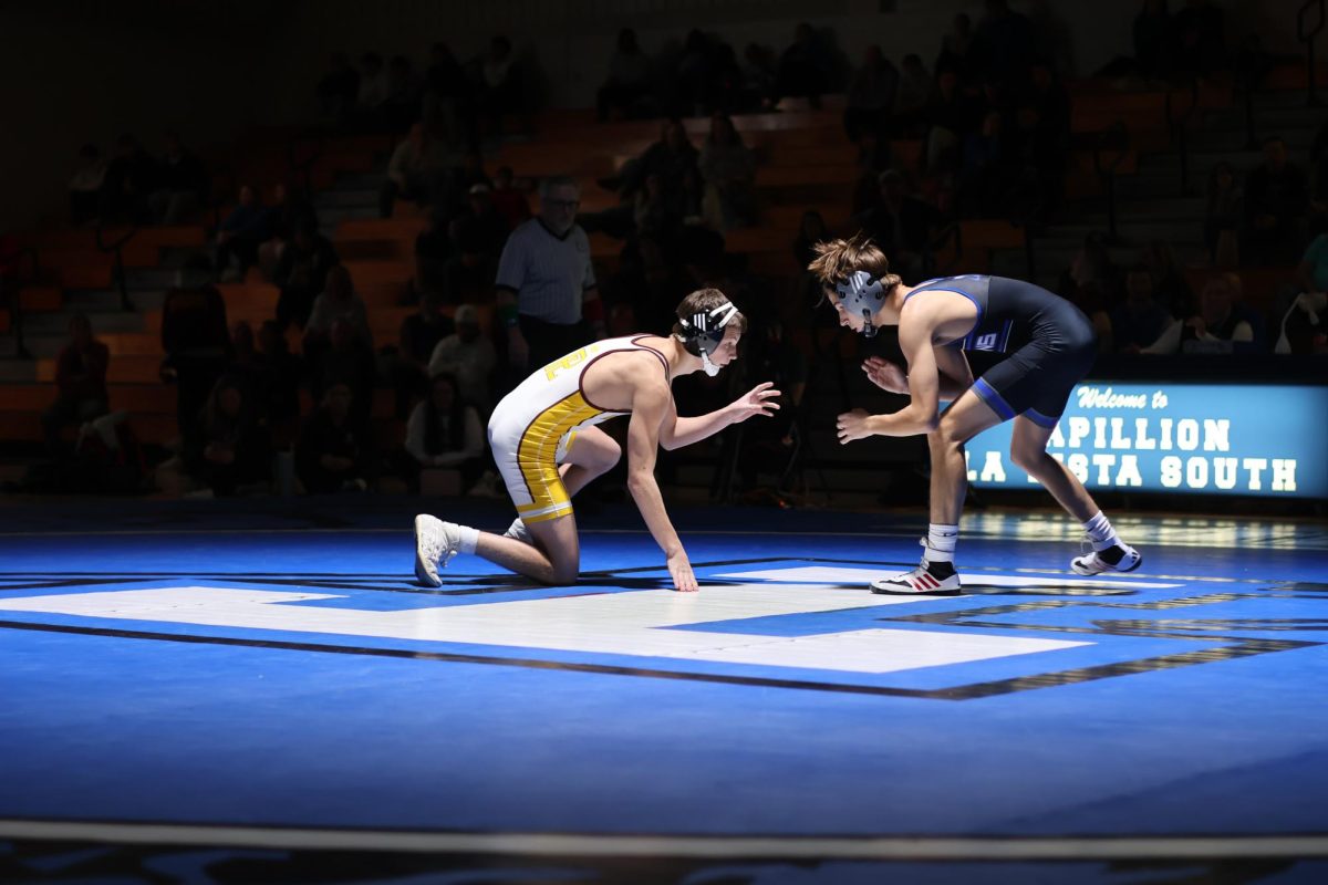 Senior wrestler Kasen Pelzer faces off his opponent at the Titan v. Monarch wrestling dual.
