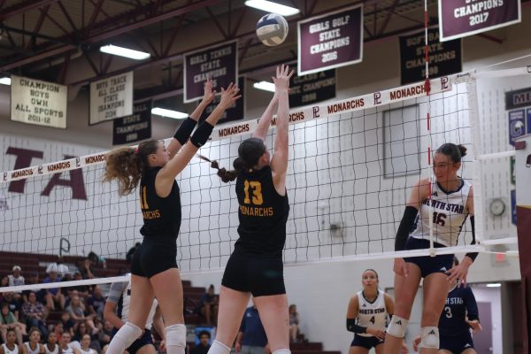 Juniors Violet Woehler and Logan Hickey go up for a block against Lincoln Northstar in a preseason match.