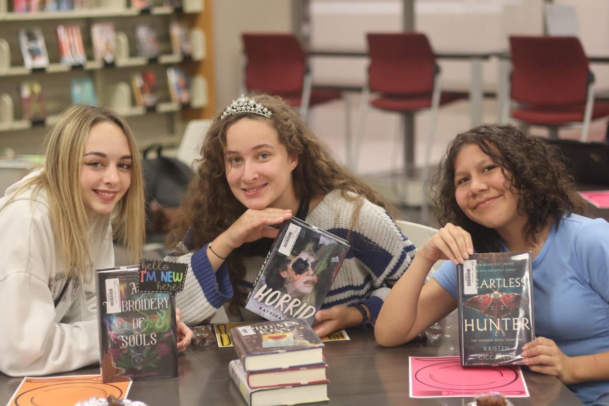 Sophomore Mackenzie Pederson, sophomore Makenzie Wilwerding and freshman Rayah Begody sitting together during the first Book Tasting.