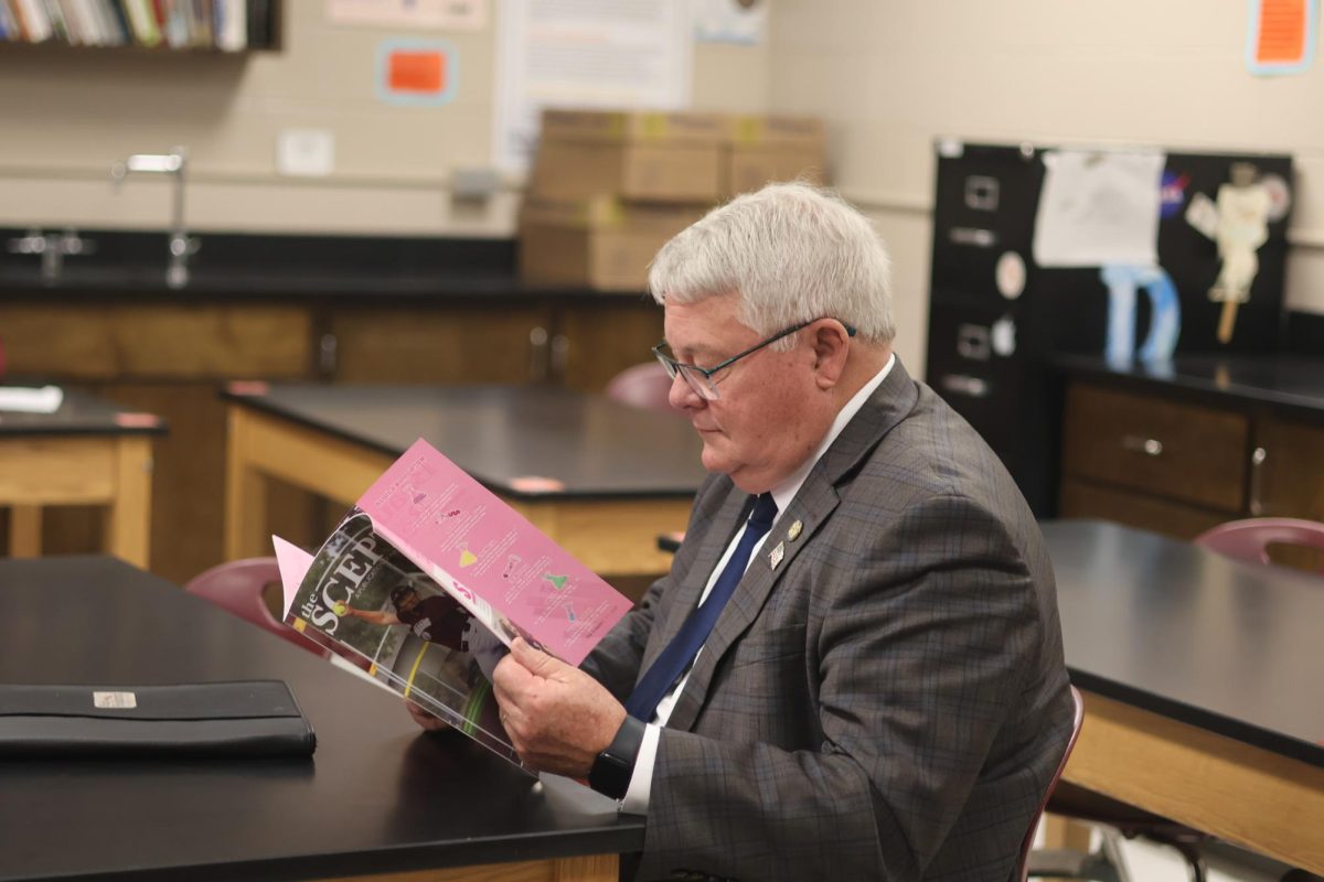 Senator Rick Holdcroft reads the PLHS Scepter in chemistry teacher Nathan Doorlag's class. Holdcroft toured the school during November after an invite from the NSEA.
