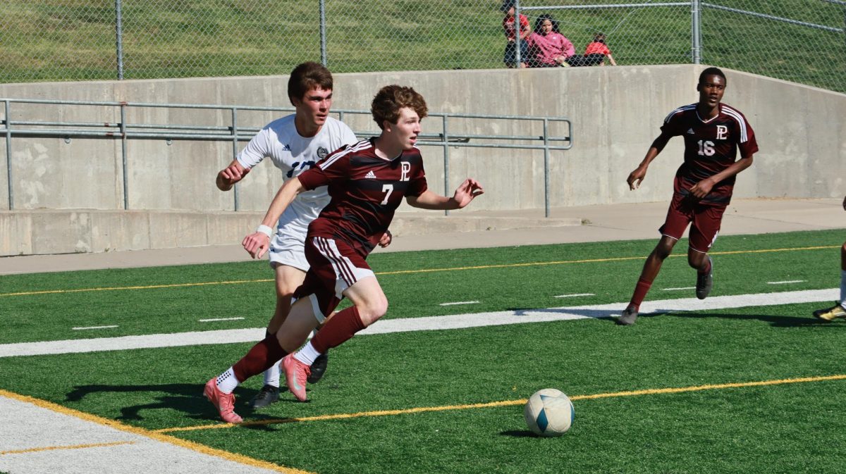 Senior Colin Llewellyn dribbles past an opponent and collects an assist after an Aiden Gurrola goal. The soccer team won against North Platte 1-0 to advance to the District Finals against Omaha South.