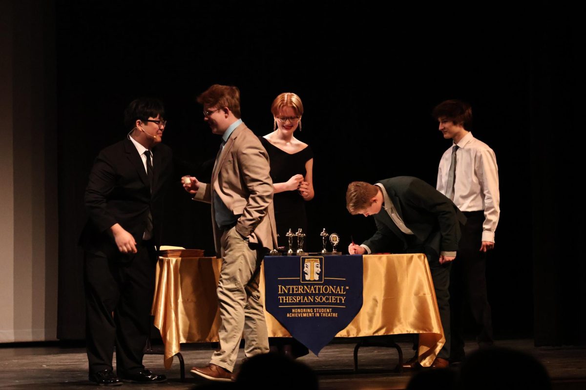 Senior Josh Spratlen and junior Char Pyle present awards to junior Christopher Reilly and freshman Jack Reilly. 