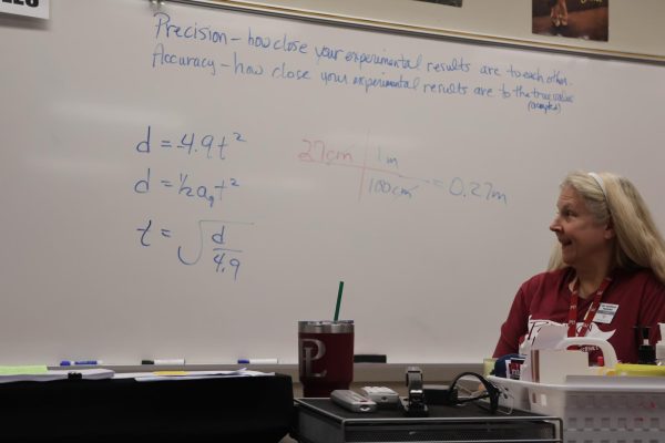 Physics teacher Mrs. Parsons looks at her work to find the time of a free fall. The class completed a free fall lab to put physics principles into practice.