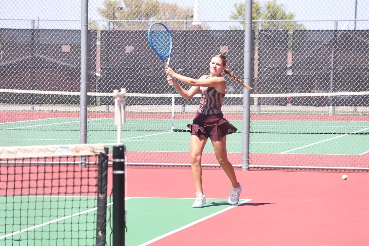 With determination, senior Reagan Jorczak returns the ball with a cross court backhand.