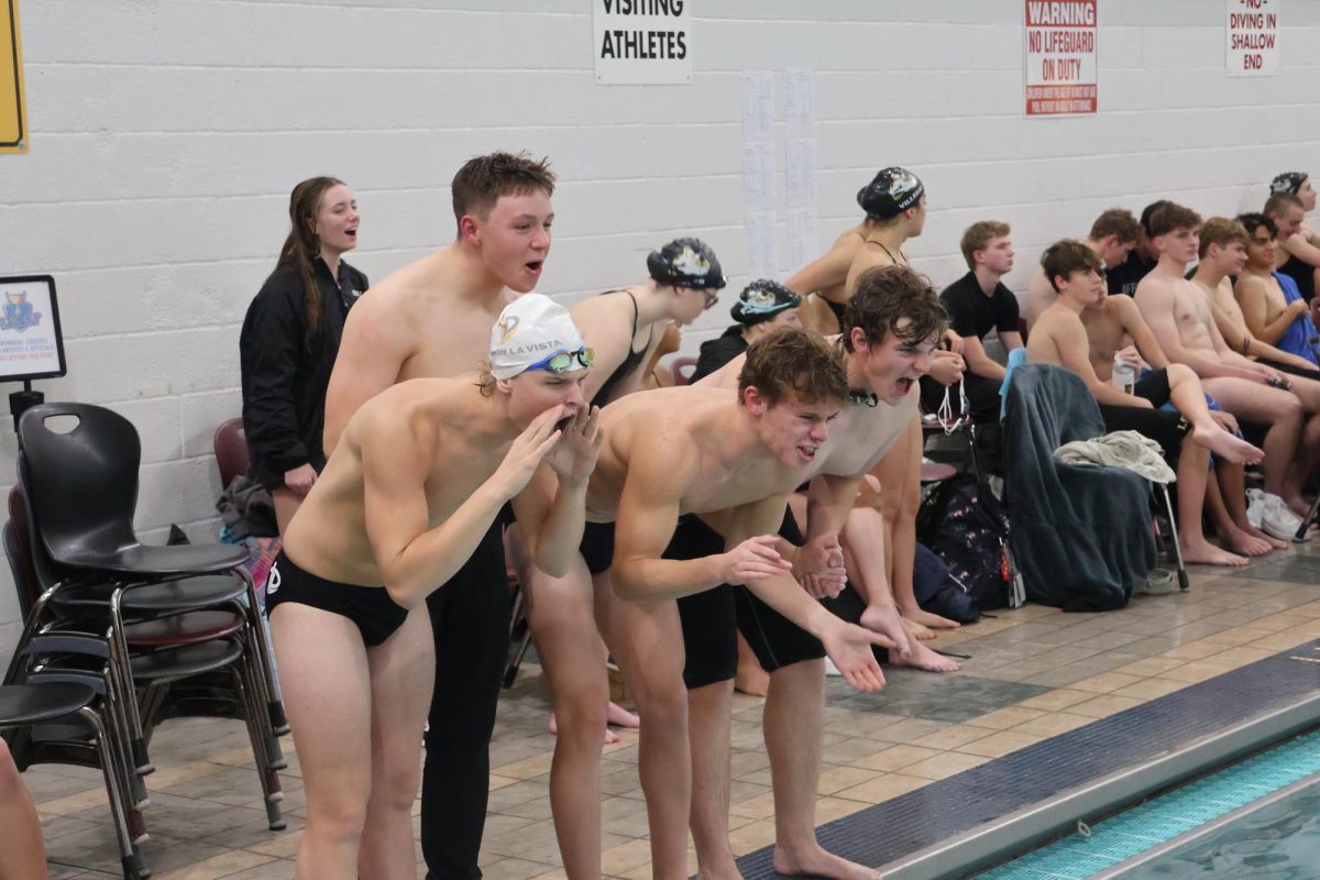 The Monarch Swim Team cheers on teammate during senior night. 